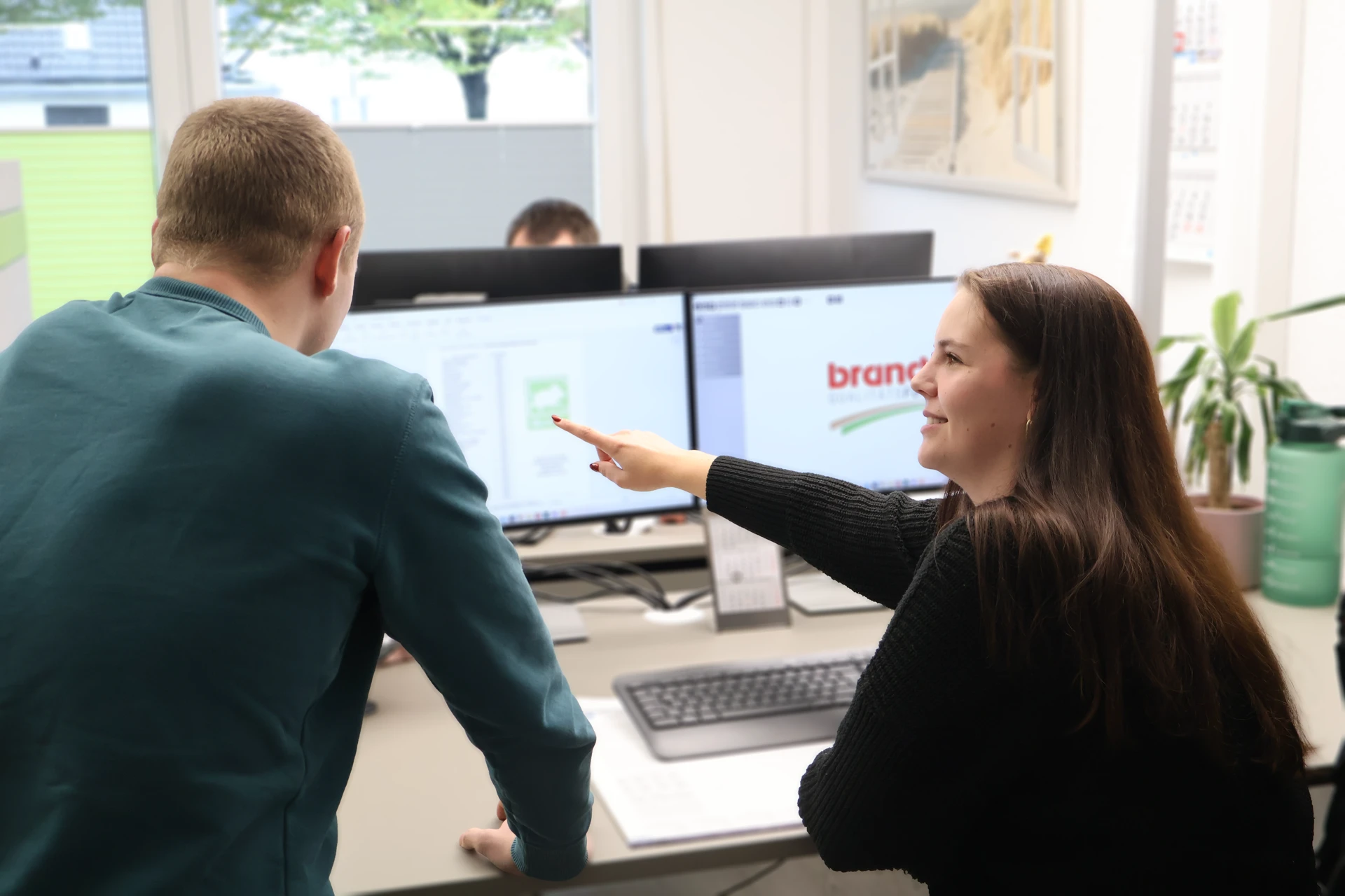 Teammeeting im Büro vor Monitoren, persönliche Beratung, Arbeitsplatz, Unternehmenskommunikation.