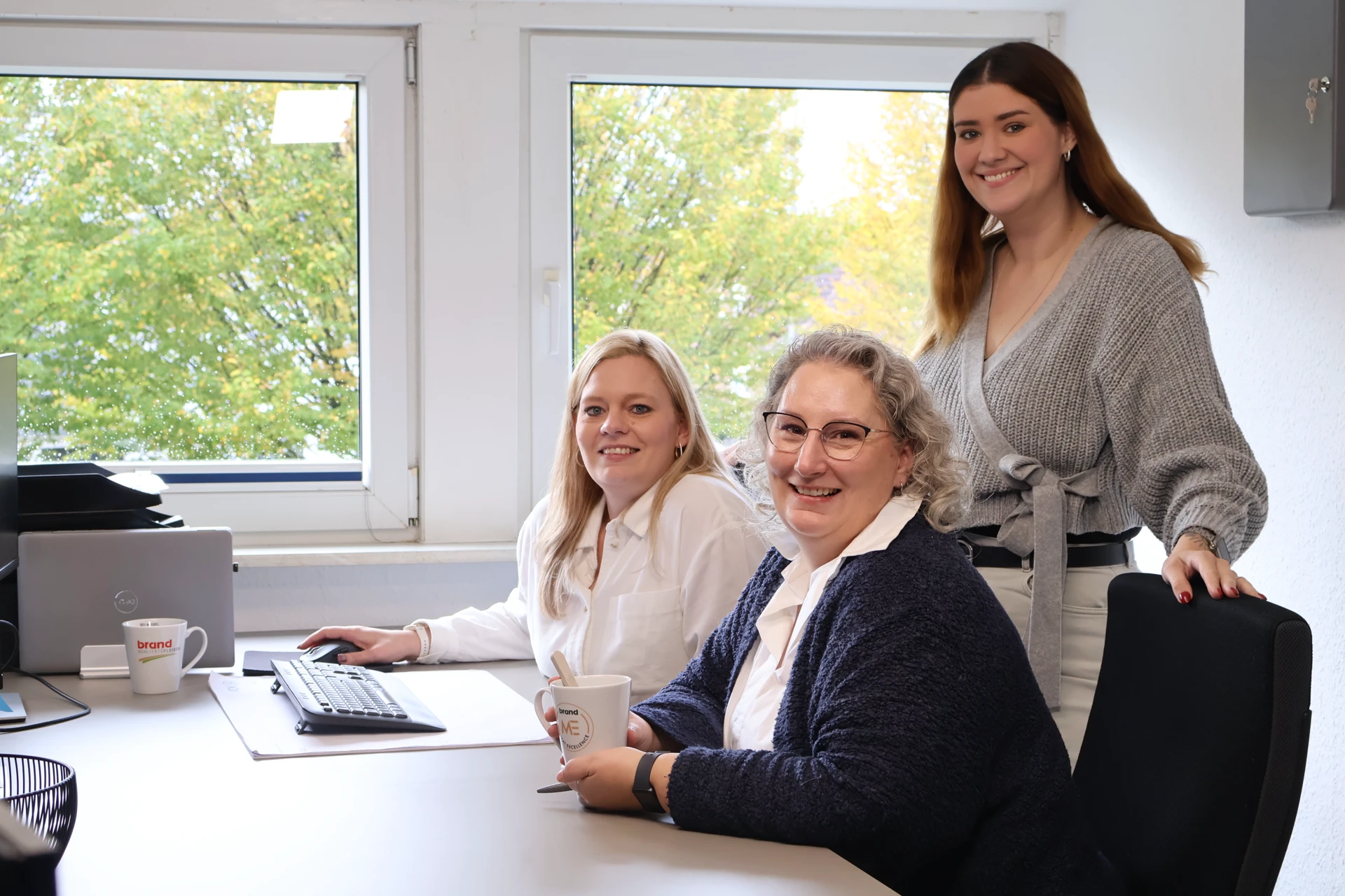 Teamfoto im Büro mit Mitarbeiterinnen, freundliche Unternehmenskultur, Arbeitsplatz, Businessporträt.